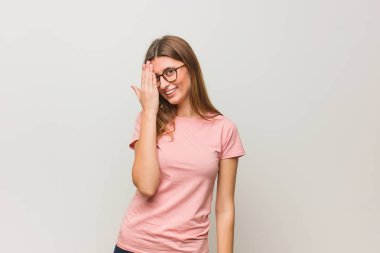 Genç Rus doğal kızı mutlu bir şekilde bağırıyor ve yüzünü eliyle örtüyor.