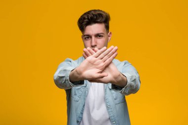 Kot gömlek giyen genç ve yakışıklı bir öğrenci inkar jesti yapıyor.