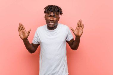 Genç Afrikalı siyahi bir adam iğrenme hareketi gösteren birini reddediyor..