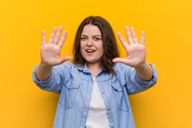 Genç kıvrımlı artı boyutu kadın elleri ile on numara gösteren.