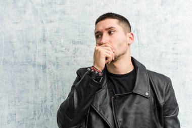 Genç rockçı düşünceli bir şekilde bir fotokopi odasına bakıyor. Ağzını eliyle kapatıyor..