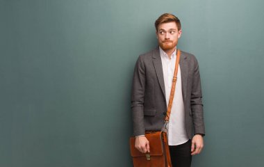 Genç kızıl saçlı iş adamı bir fikir düşünüyor.