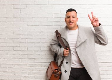 Genç Latin iş adamı, zafer jesti yaparak eğleniyor ve mutlu.