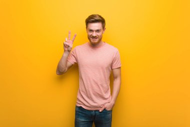 Genç Kızıl saçlı adam eğlenceli ve mutlu zafer bir jest yapıyor