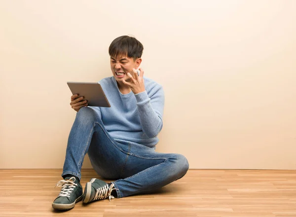 Young Chinese Man Sitting Using His Tablet Angry Upset — Stock Photo, Image