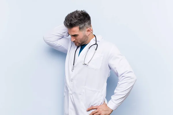 Jovem Bonito Médico Homem Tocando Parte Trás Cabeça Pensando Fazendo — Fotografia de Stock