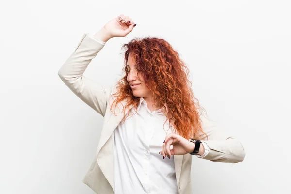 Young natural redhead business woman isolated against white background celebrating a special day, jumps and raise arms with energy.