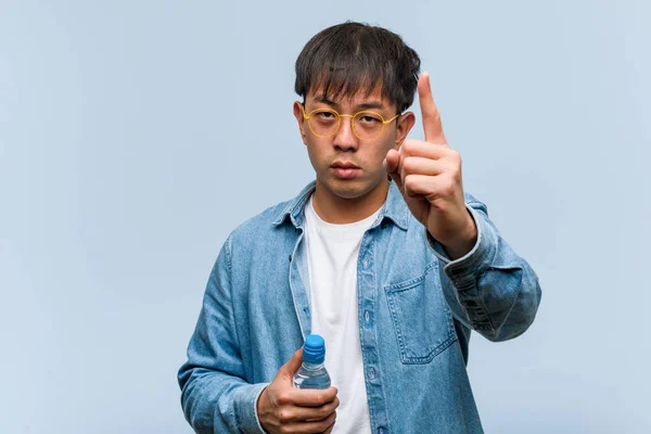 Joven Chino Sosteniendo Una Botella Agua Mostrando Número Uno — Foto de Stock