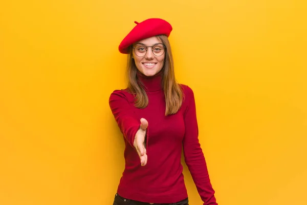 Young french artist woman reaching out to greet someone