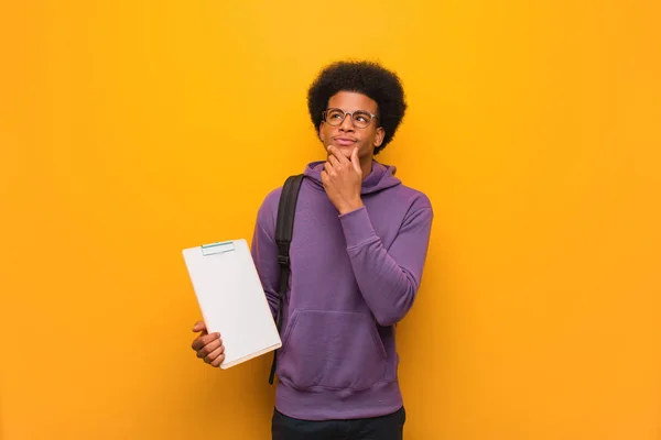 Jovem Estudante Afro Americano Segurando Uma Prancheta Duvidosa Confusa — Fotografia de Stock