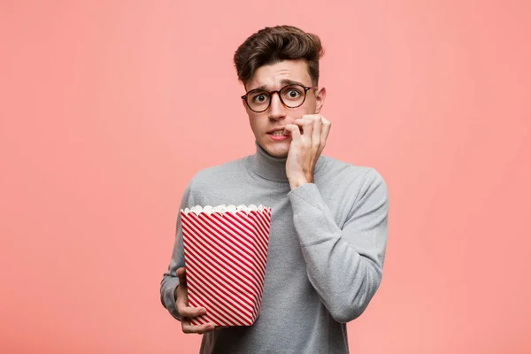 Young Intellectual Man Holding Popcorn Bucket Crossing Fingers Having Luck — Stock Photo, Image