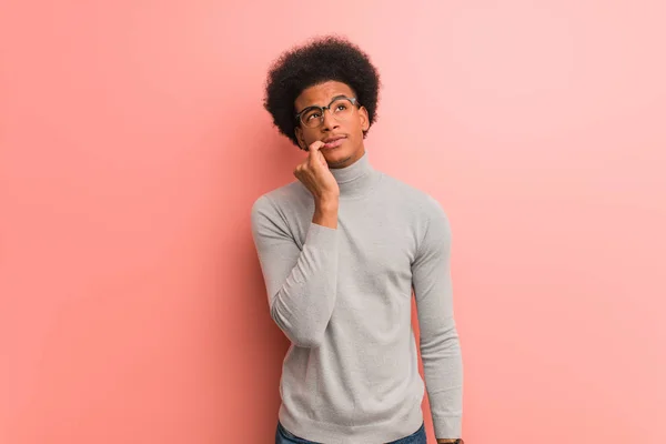 Joven Afroamericano Sobre Una Pared Rosa Dudando Confundido — Foto de Stock