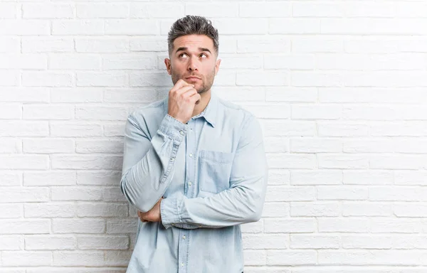 Young Handsome Man Bricks Wall Looking Sideways Doubtful Skeptical Expression — Stock Photo, Image