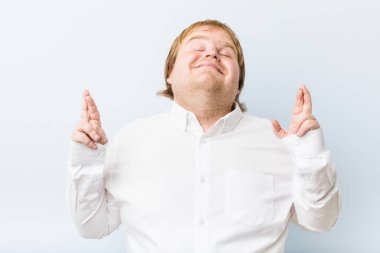 Genç otantik kızıl saçlı şişman adam şans için parmakgeçiş