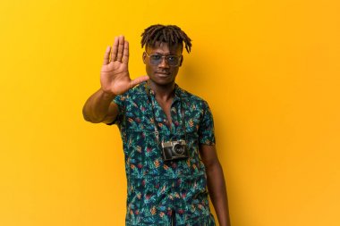 Genç siyah Rasta tatil giyiyordu. Elini uzatmış, dur işareti gösteriyordu. Seni engelliyordu..