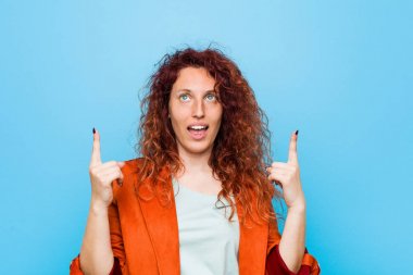 Genç kızıl saçlı zarif kadın, iki ön parmağı da boş bir alan gösteriyor..