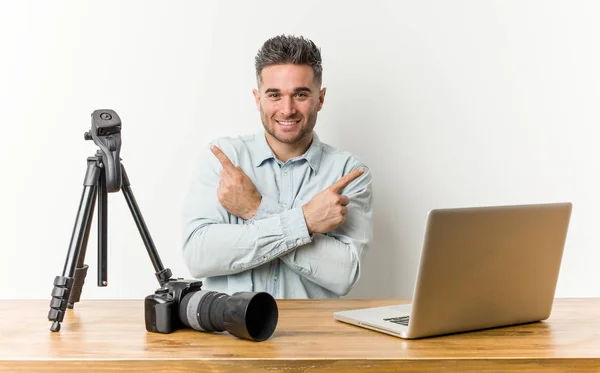 Young handsome photography teacher points sideways, is trying to choose between two options.