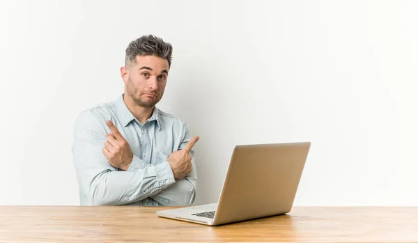 Young Handsome Man Working His Laptop Points Sideways Trying Choose — Stock Photo, Image