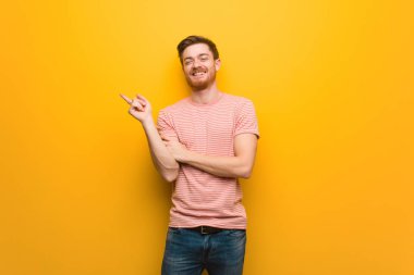 Genç kızıl saçlı adam parmakla yan işaret