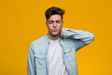 Kotlu gömlek giyen genç ve yakışıklı bir öğrenci yerleşik yaşam tarzından dolayı boyun ağrısı çekiyor..