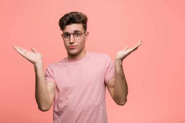 Genç, havalı, beyaz bir adam şüphe ediyor ve sorgulamada omuzlarını silkiyor..