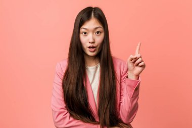 Pembe takım elbiseli Çinli genç bir kadının harika bir fikri var, yaratıcılık kavramı..