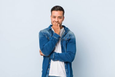 Genç yakışıklı filipinli adam tırnakısırma, sinir ve çok endişeli.