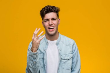 Kot gömlek giyen genç ve yakışıklı bir öğrenci öfkeden bağırıyor..