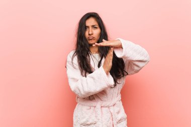 Pijama giyen genç Hintli kadın mola hareketi yapıyor..