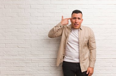 Genç Latin adam parmaklarıyla hayal kırıklığı jesti yapıyor.