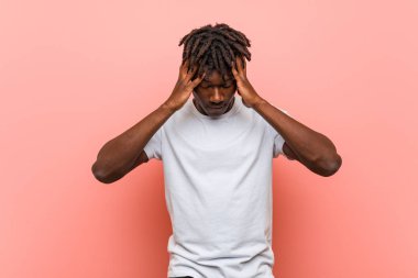 Genç Afrikalı siyah adam tapınaklara dokunuyor ve baş ağrısı yaşıyor.