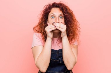 Kot pantolon giyen kızıl saçlı genç ve güzel bir kadın elleriyle ağzını kapatırken şok oldu..