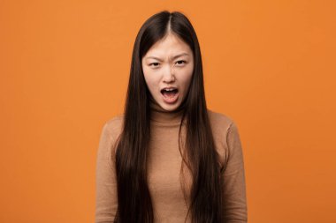 Genç, güzel Çinli kadın çok sinirli ve agresif bağırıyor..