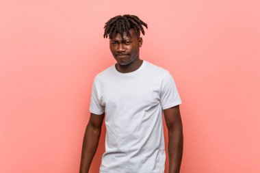 Genç Afrikalı siyahi adam şaşkın, şüpheli ve güvensiz hissediyor..