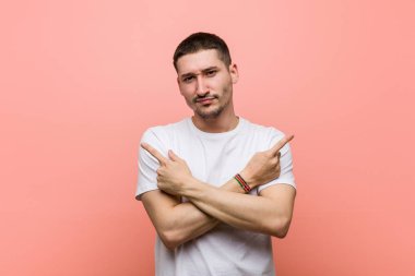 Genç adam iki seçenek arasında seçim yapmaya çalışıyor..