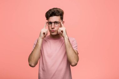 Kafkasyalı genç adam bir işe odaklanmış, parmaklarını işaret ediyor..