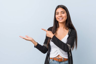 Genç, doğal ve güzel bir Arap kadın avucunda bir kopya yeri tutarken heyecanlanıyor..