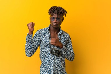 Genç siyah Rasta adam tatilde. Kafasının arkasına dokunuyor, düşünüyor ve bir seçim yapıyor..