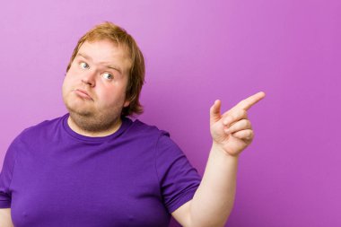 Genç otantik kızıl saçlı şişman adam işaret parmağıyla işaret ettiği için heyecanlı..