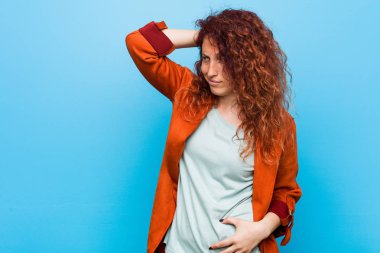 Genç kızıl saçlı zarif kadın başının arkasına dokunuyor, düşünüyor ve bir seçim yapıyor..