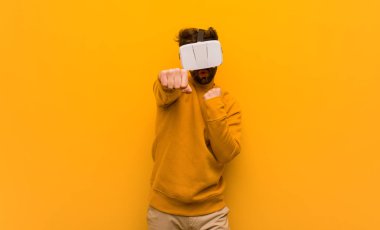 Sanal gerçeklik gözlüğü takan genç adam.