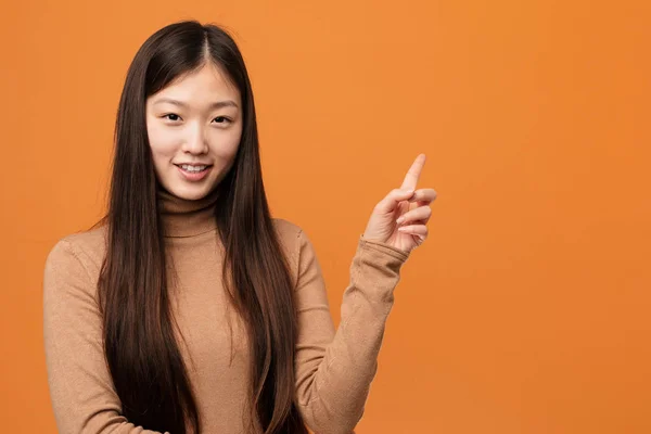 Jovem Mulher Chinesa Bonita Sorrindo Alegremente Apontando Com Dedo Indicador — Fotografia de Stock