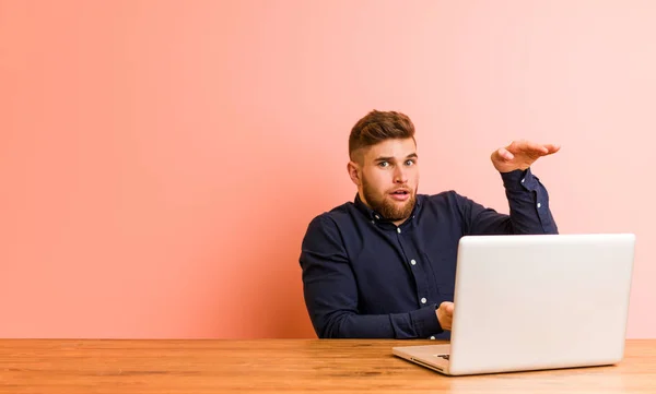 Young Man Working His Laptop Shocked Amazed Holding Copy Space — 스톡 사진