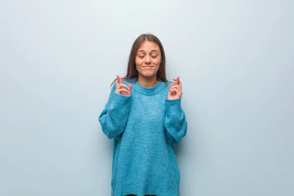 Jovem Mulher Bonita Vestindo Uma Camisola Azul Cruzando Dedos Para — Fotografia de Stock