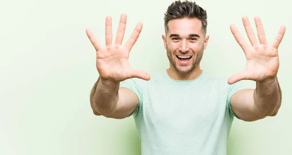 Νεαρός Όμορφος Άντρας Πράσινο Φόντο Που Δείχνει Νούμερο Δέκα Χέρια — Φωτογραφία Αρχείου