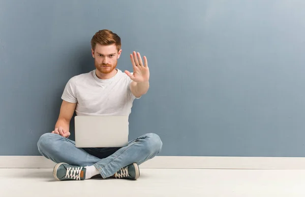 Joven Estudiante Pelirrojo Sentado Suelo Poniendo Mano Frente Está Sosteniendo — Foto de Stock