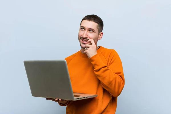 Young Caucasian Man Holding Laptop Relaxed Thinking Something Looking Copy — Stock Photo, Image