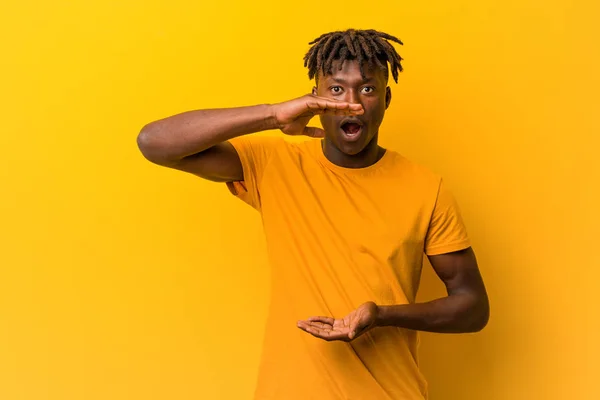 Young Black Man Wearing Rastas Yellow Background Holding Something Both — Stock Photo, Image
