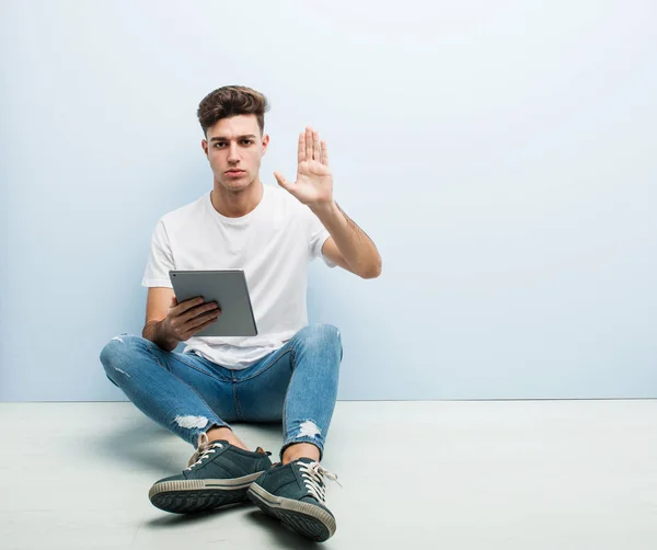 Jongeman Met Een Tablet Binnen Staande Met Uitgestrekte Hand Met — Stockfoto