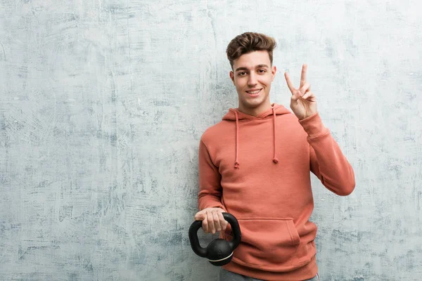 Young Sport Man Holding Dumbbell Showing Number Two Fingers — ストック写真